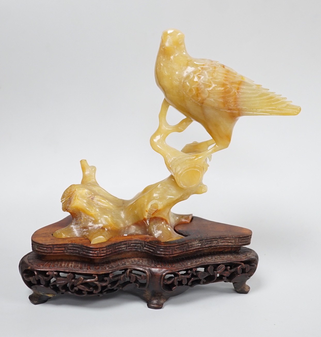 A Chinese chalcedony carving of a bird, wood stand, total height 15.5 cm